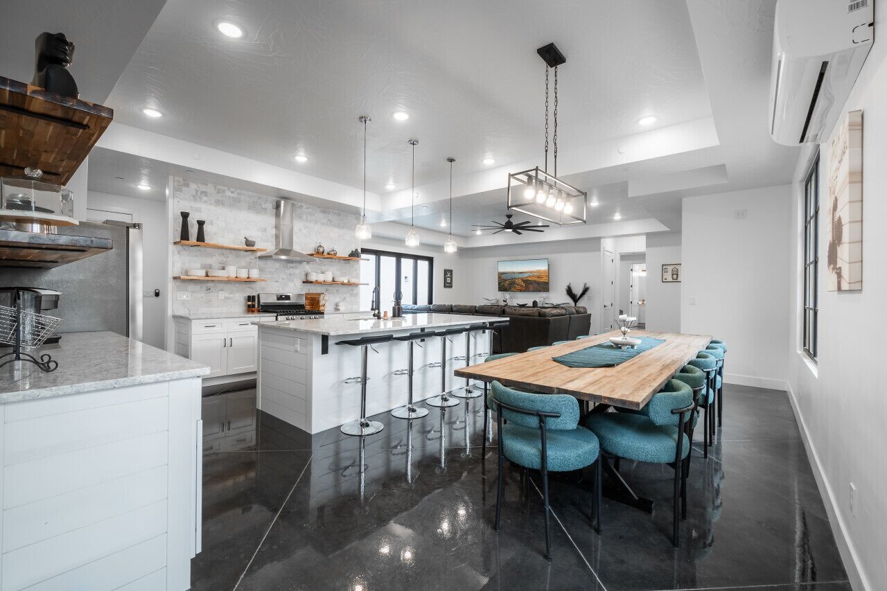 Een moderne keuken met een centraal eiland, barkrukken en hanglampen.