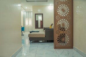Una sala de estar moderna con un sofá, una mesa de centro y un panel decorativo con diseños intrincados.