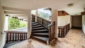 A staircase with wooden railings leading to a balcony overlooking a mountainous area. - Apartment 'Les Avenières' with Balcony (Châtel)