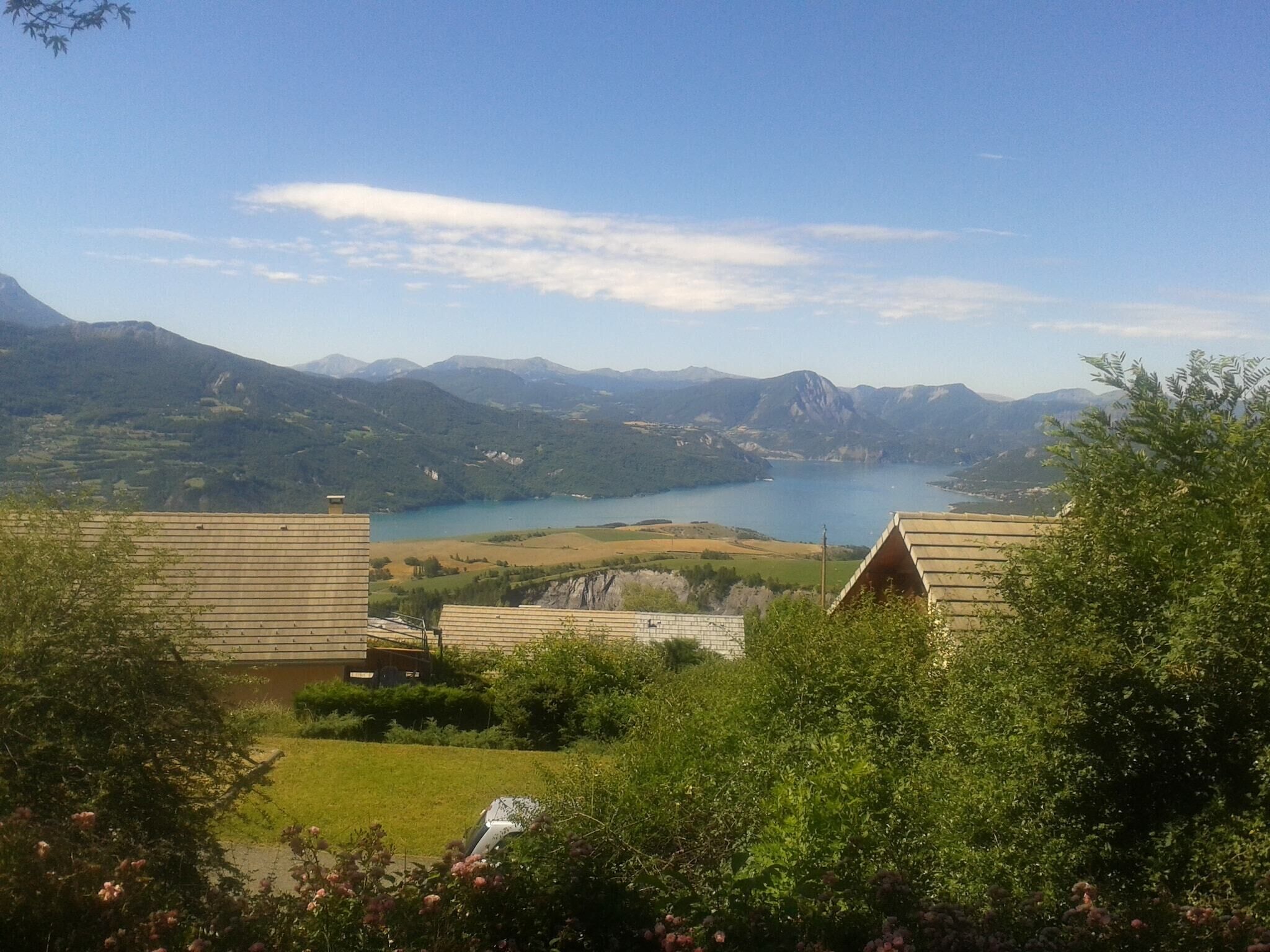 Vista d'un paisatge de muntanyes, amb un llac i edificis al primer pla.