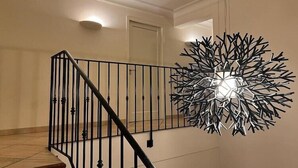 A staircase with a black metal railing and a modern, abstract wall art piece. - Elegant Villa with Pool, Cabris (Cabris)