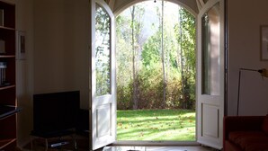 An open door leading to a garden with trees and grass. - Elegant Villa with Pool, Cabris (Cabris)