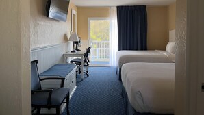 Ein Hotelzimmer mit einem Bett, einem Schreibtisch mit Stuhl, einem an der Wand befestigten Fernseher und einem Fenster mit Blick ins Freie.