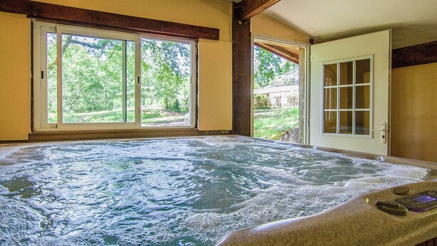 A hot tub with a view of a garden through large windows. - Mansion  in Bourgnac with garden (Bourgnac)
