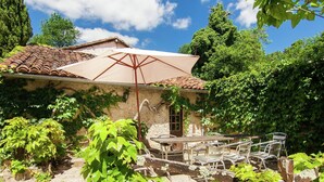 A rustic outdoor dining area with a table and chairs, a pergola with a white canopy, and lush greenery. - Mansion  in Bourgnac with garden (Bourgnac)