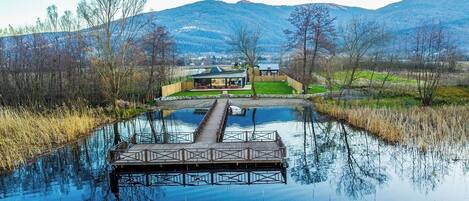 A riverside dock with a house in the background.