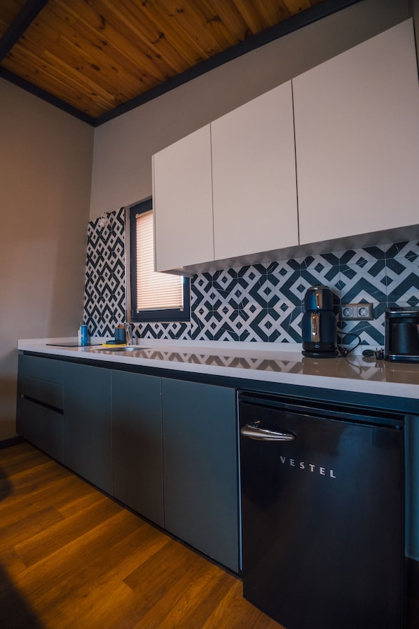A modern kitchen with a wooden ceiling, patterned backsplash, and a black refrigerator labeled 'VESTEL'. - Vital Göl (Sapanca)