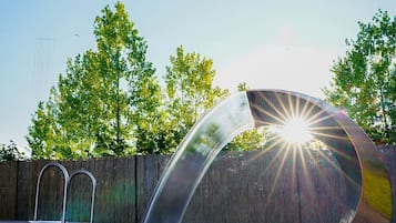 Zona de hidromasaje con terraza de madera y estructura metálica que refleja la luz del sol.