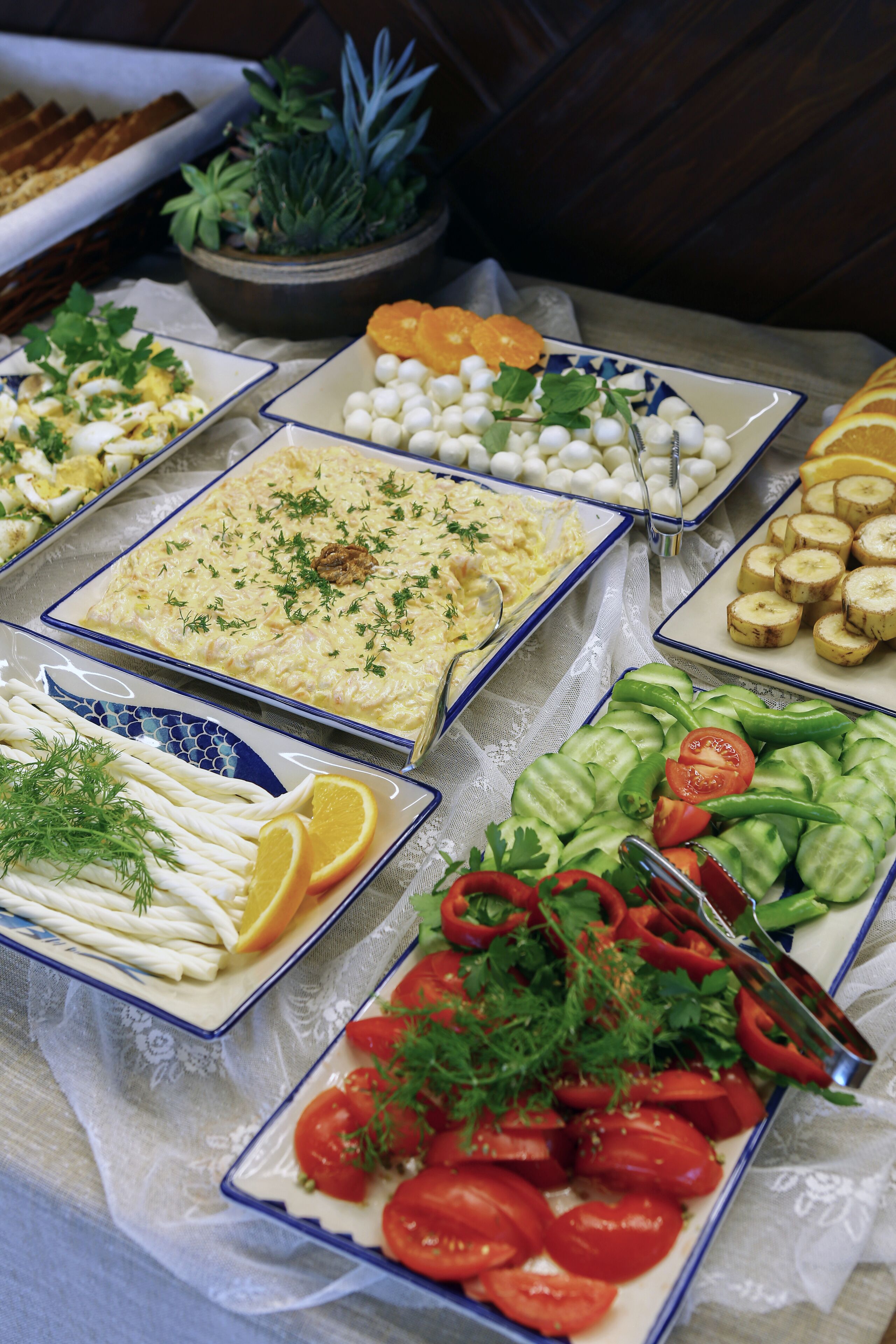 Una mesa de buffet con diversos platos, entre ellos ensaladas, verduras y un pastel de carne.