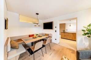 Une cuisine moderne avec des meubles en bois, un four encastré et une grande fenêtre.