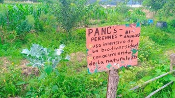 Letrero en un jardín con texto sobre el uso intensivo de la biodiversidad y el conocimiento de la naturaleza.