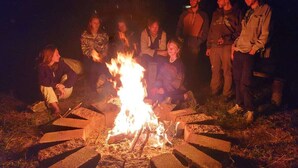 A group of people gathered around a fire pit in an outdoor setting. - The Hub (San Juan La Laguna)