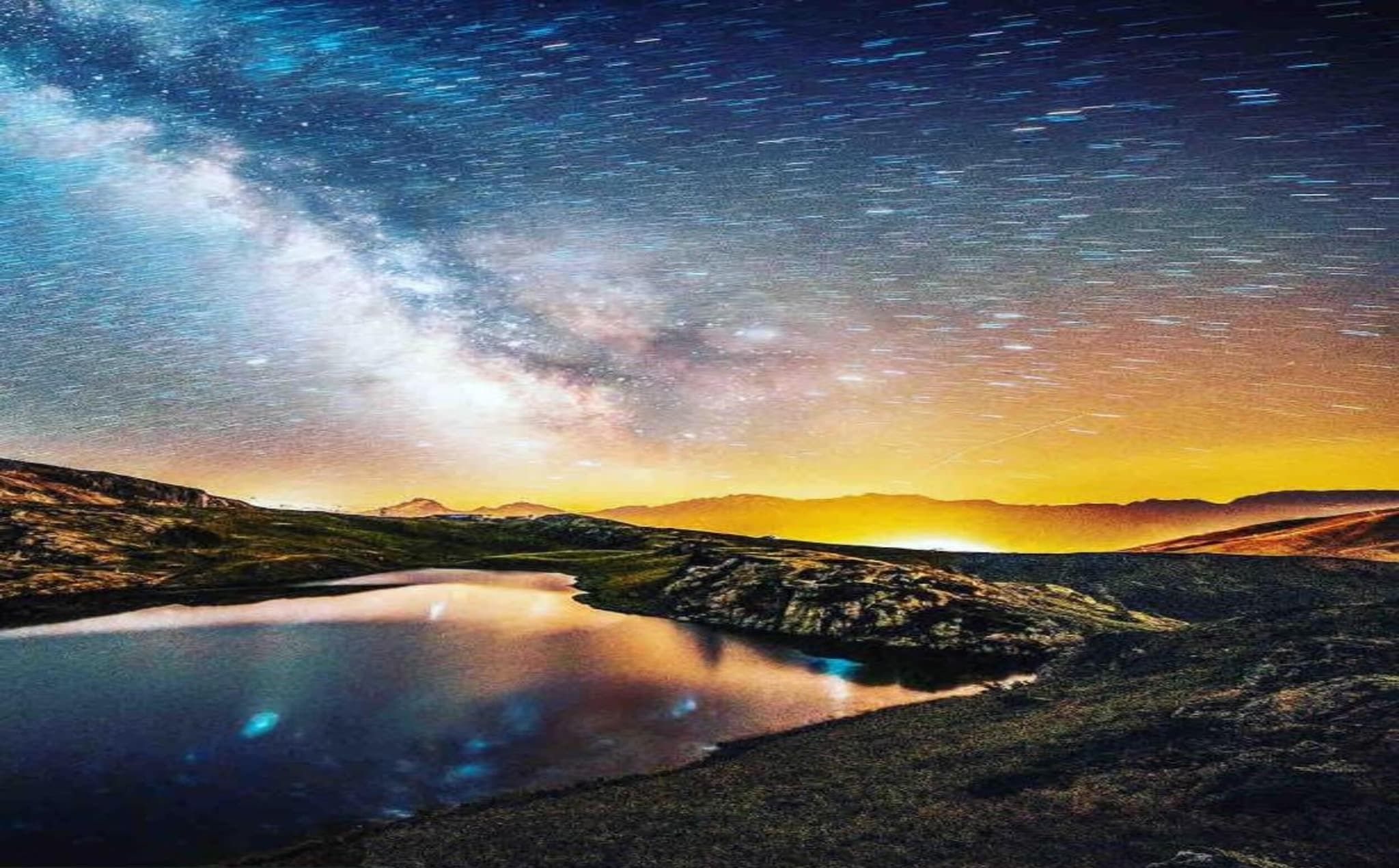 A landscape with a lake, mountains, and a starry sky.