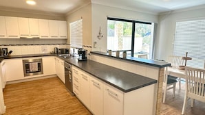 Una cocina moderna con armarios blancos, encimera negra y ventana que aporta luz natural.