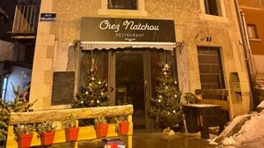 Ein Gebäude mit einem Schild, auf dem 'Chez Natchou Restaurant' steht, und einem Weihnachtsbaum davor.