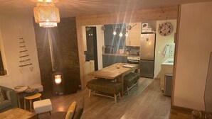 Ein gemütliches Wohnzimmer mit Kamin, Essbereich und einer Küche mit modernen Geräten.