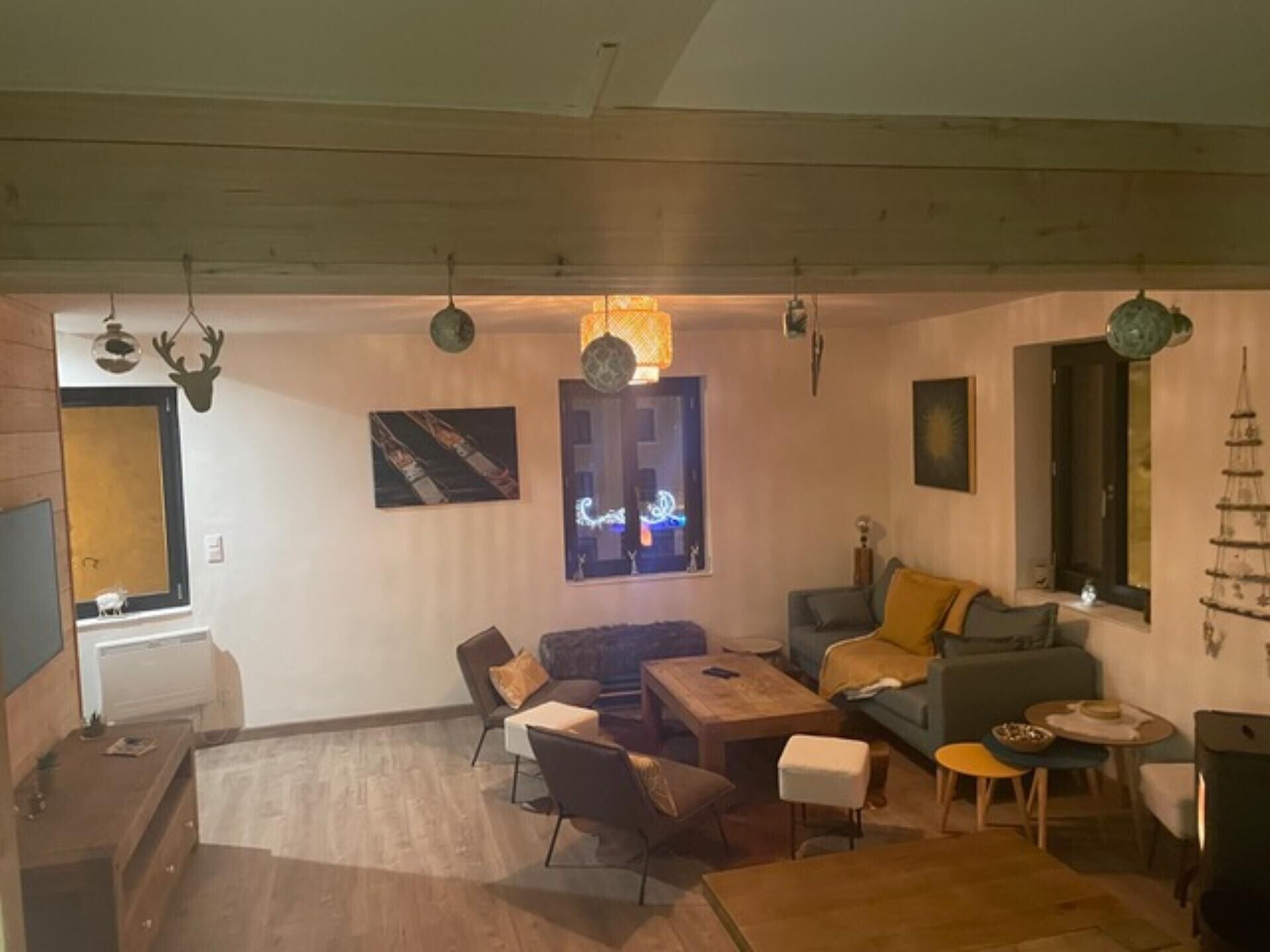 Una sala de estar acogedora con chimenea, un comedor y una cocina con ventana.