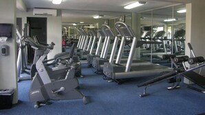 A gym with multiple treadmills, exercise bikes, and weight machines.