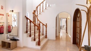 A staircase with wooden balusters, a mirror, a fire extinguisher, and a wooden console table. - Villa 'Casa Judite' with Private Terrace, Balcony and Wi-Fi (Lagoa)