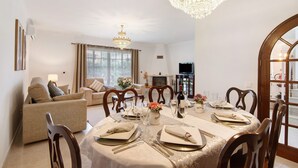 A dining room with a chandelier, a fireplace, and a television in the background. - Villa 'Casa Judite' with Private Terrace, Balcony and Wi-Fi (Lagoa)