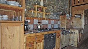 A kitchen with wooden cabinets, a stove, and a dishwasher. - Villa in Ayguatébia-Talau with Garden & BBQ (Ayguatebia-Talau)