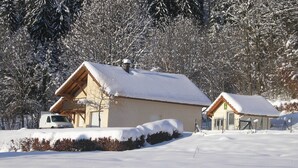 A snow-covered cabin with a wooden exterior and a small porch. - Holiday Home in Vosges with Garden and BBQ (Le Haut-Du-Them)