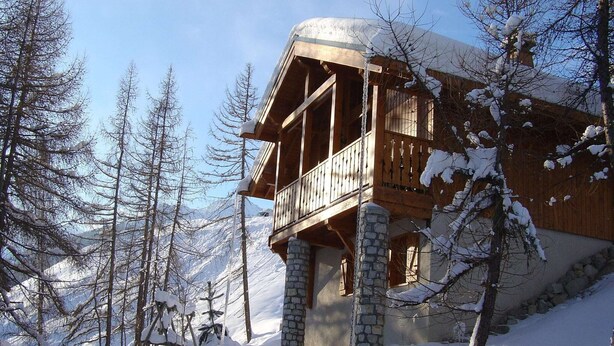 A wooden chalet with a balcony, surrounded by snow-covered trees and mountains. - Chalet in Vallandry near Paradiski Ski Area (Vallandry)