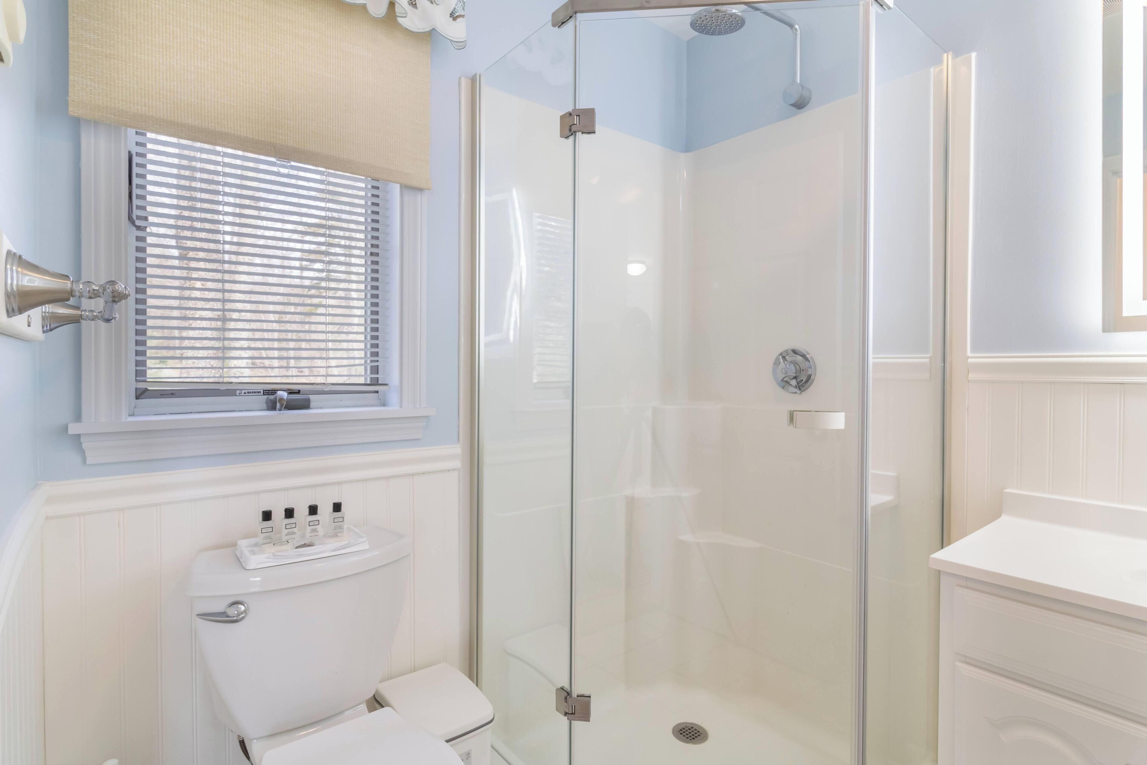 Ein Badezimmer mit Duschkabine, Toilette und Waschbecken.