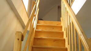 Eine Holztreppe mit Handlauf, die zu einer oberen Etage führt.