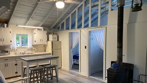 A cozy cabin-style interior with a kitchen, dining area, and a sleeping loft. - Waterfront cabin with access to Long Lake and Mud Lake.   (Sinclair)