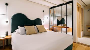 Ein modernes Schlafzimmer mit einem großen Bett, einem Nachttisch aus Holz, einer Nachttischlampe und einem großen Spiegel.