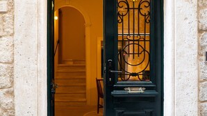 Una porta negra amb un disseny metàl·lic decoratiu i un motiu floral.