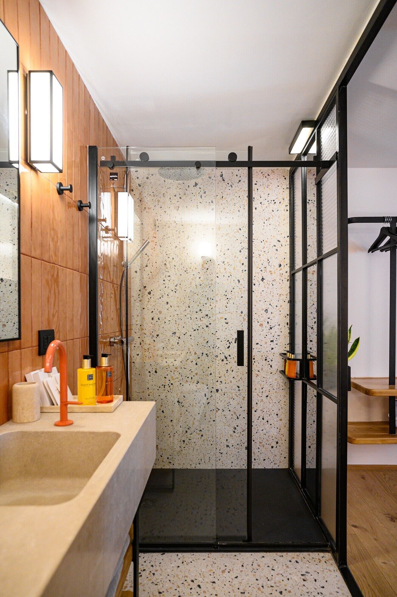 A modern bathroom with a shower, a sink with a mirror, and a wooden vanity.