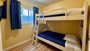 A bunk bed room with a window, curtains, and a ceiling light. - 2 Bedroom PET-FRIENDLY Family Suite at Ocean-Side Property! (Monterey)
