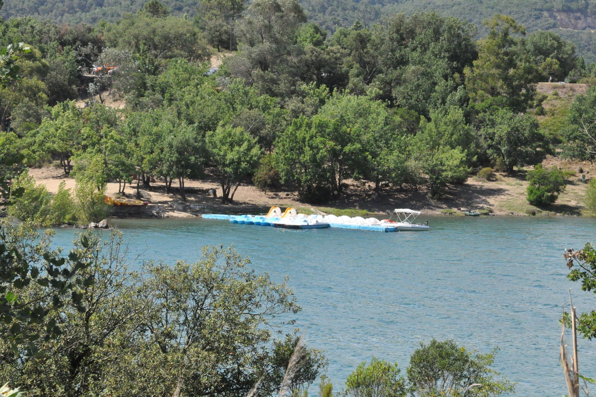 A river with a floating platform carrying several boats.