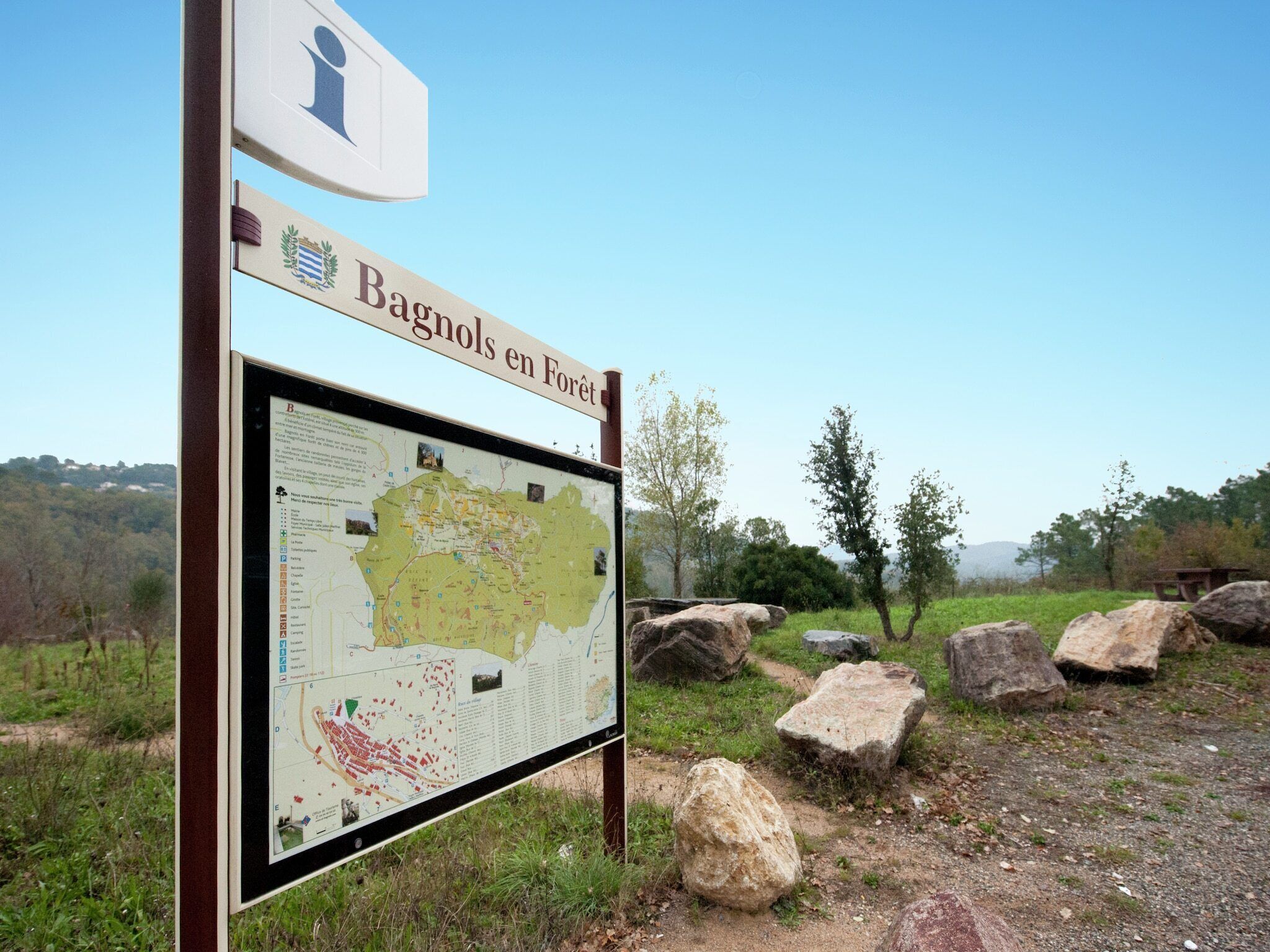A sign with a map and the text 'Bagnols en Forêt'.