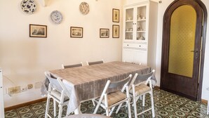 Un comedor con una mesa, sillas, un armario y baldosas de suelo estampadas.
