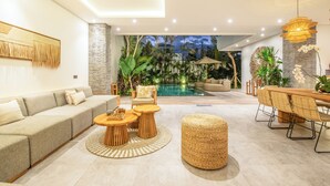 Ein modernes Wohnzimmer mit Sofa, Couchtisch und Essbereich.