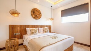 Ein modernes Schlafzimmer mit einem Holz-Kopfteil, einem großen Bett mit weißer Bettwäsche, zwei Wandleuchten, einem runden Holzbild und einem Fenster mit Jalousien.