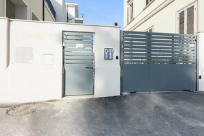 A gated entrance with a metal gate and a door marked 'N° 13'.