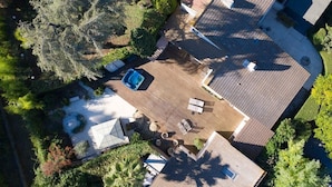 An aerial view of a residential area with a swimming pool, patio furniture, and a well-maintained garden. - 06V - Beautiful villa with spa, pool and tennis (Biot)