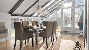 A modern dining room with a high ceiling, large windows, and a view of the outdoors. - Lovely home in Hadsund with WiFi (Hadsund)
