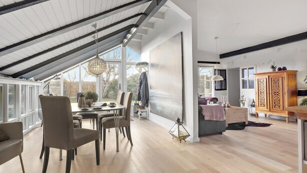 A spacious loft with a high ceiling, large windows, and a dining area with a table and chairs. - Lovely home in Hadsund with WiFi (Hadsund)