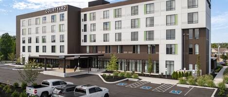 Et Courtyard by Marriott hotel med moderne design, flere parkeringspladser og et anlagt indgangsparti.