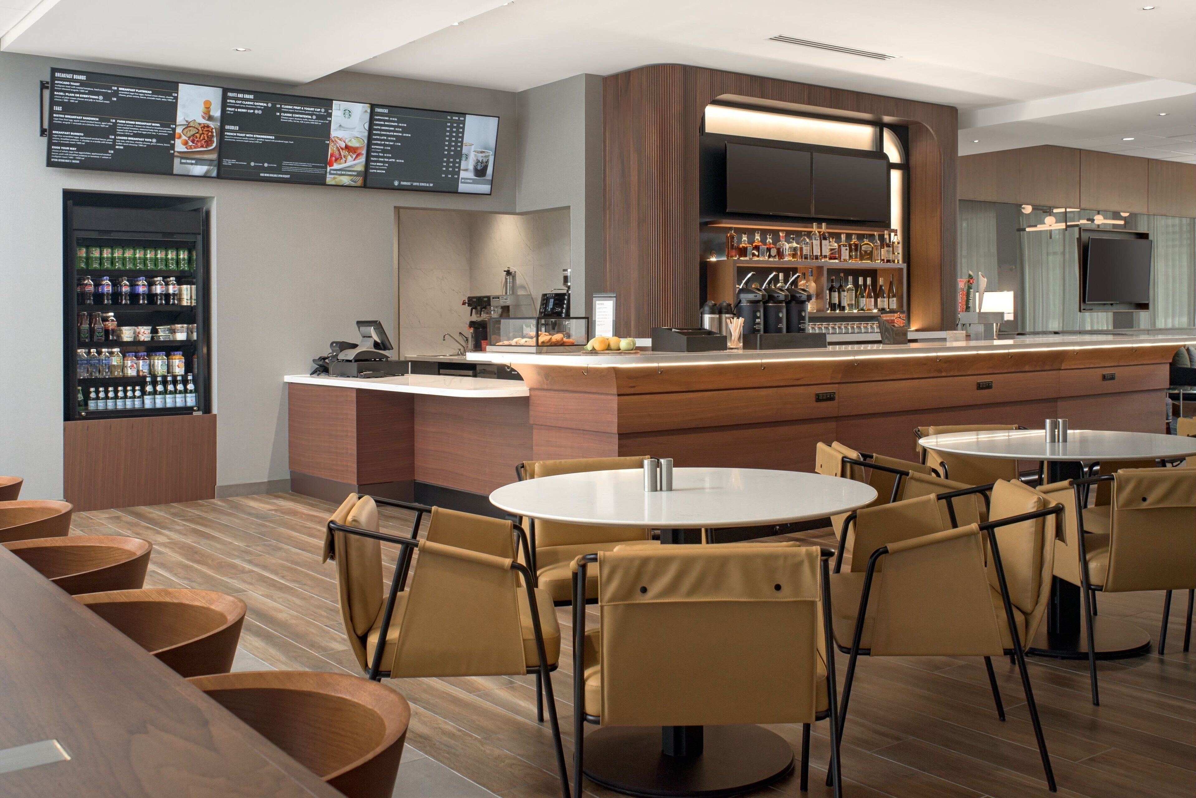 A modern restaurant with a bar area, multiple seating options, and a menu display.