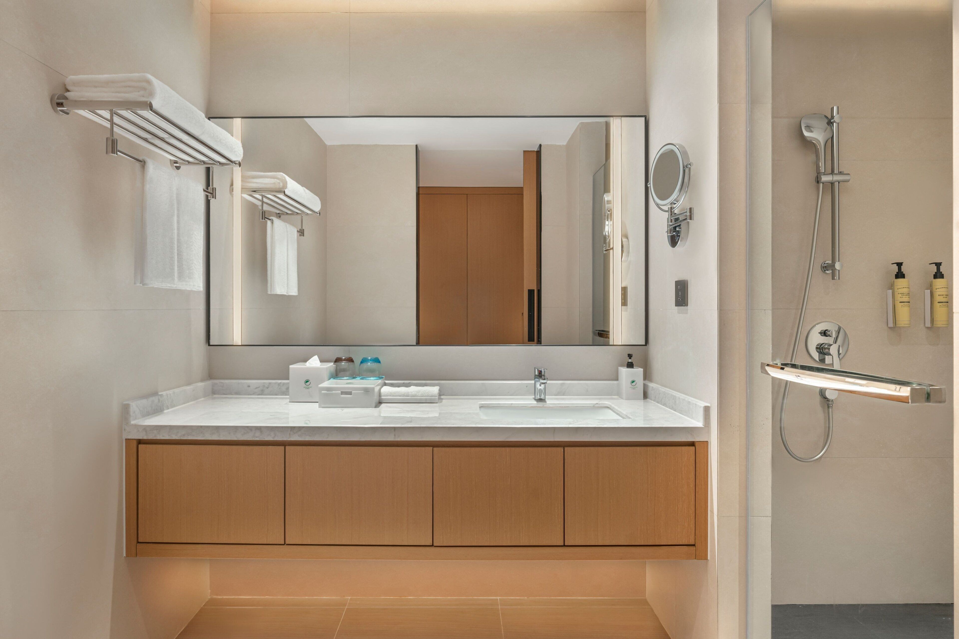 Un baño moderno con un espejo grande, un lavabo y una ducha.