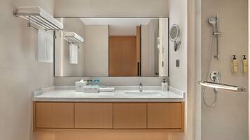 Un baño moderno con un espejo grande, un lavabo y una ducha.