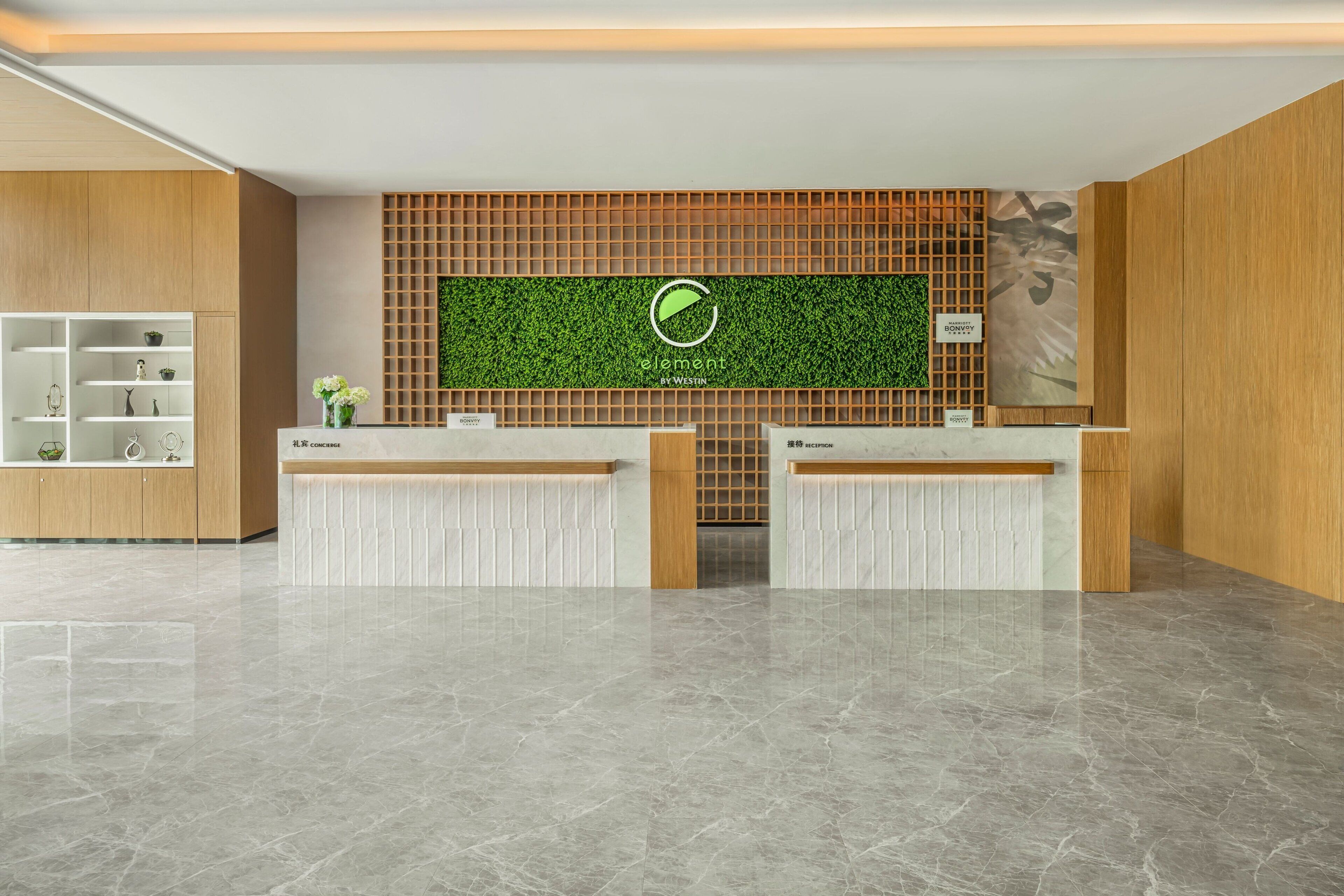 A reception area with a green wall, wooden paneling, and a marble floor.