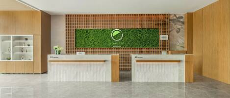 A reception area with a green wall, wooden paneling, and a marble floor.