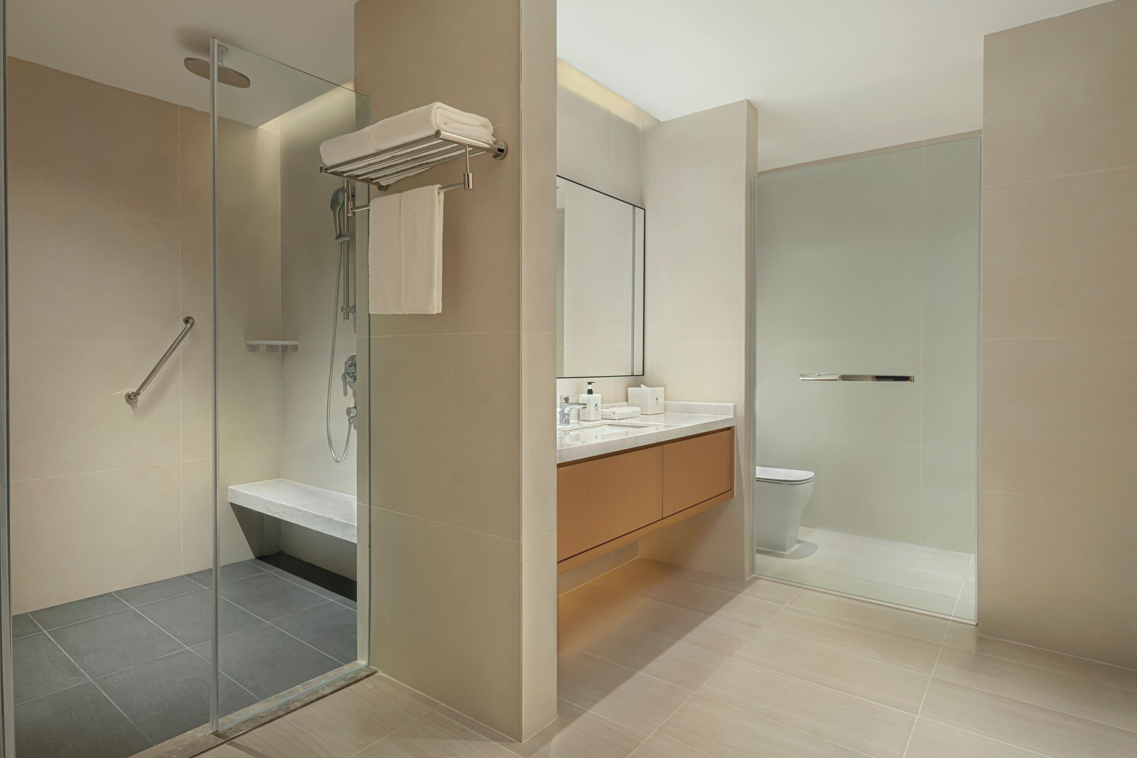 Ein modernes Badezimmer mit einer gläsernen Duschkabine, einem weißen Waschbecken und einer Toilette.